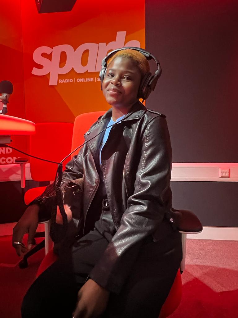 Oluwatobiloba Olanigba also known as Tobiloba Olanigba sitting in a studio at Spark Radio, and speaking into the microphone.